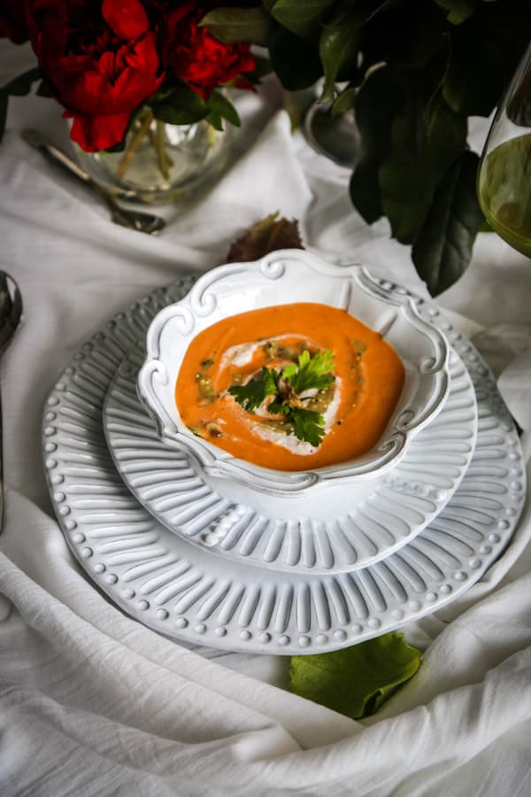 vegan curried cauliflower soup in a white bowl with salsa and cashew cream