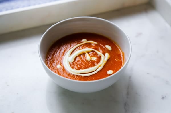 gluten free tomato soup in a bowl with white drizzle