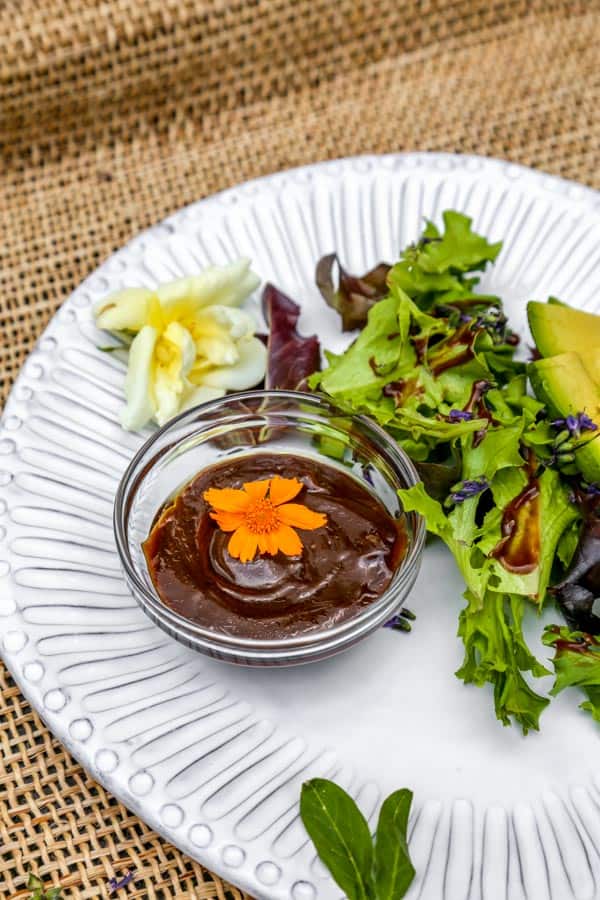 Balsamic Vinaigrette with Dijon Mustard in a bowl on a plate served with salad