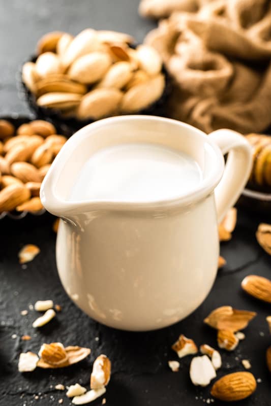 cup of almond milk with almonds and honey