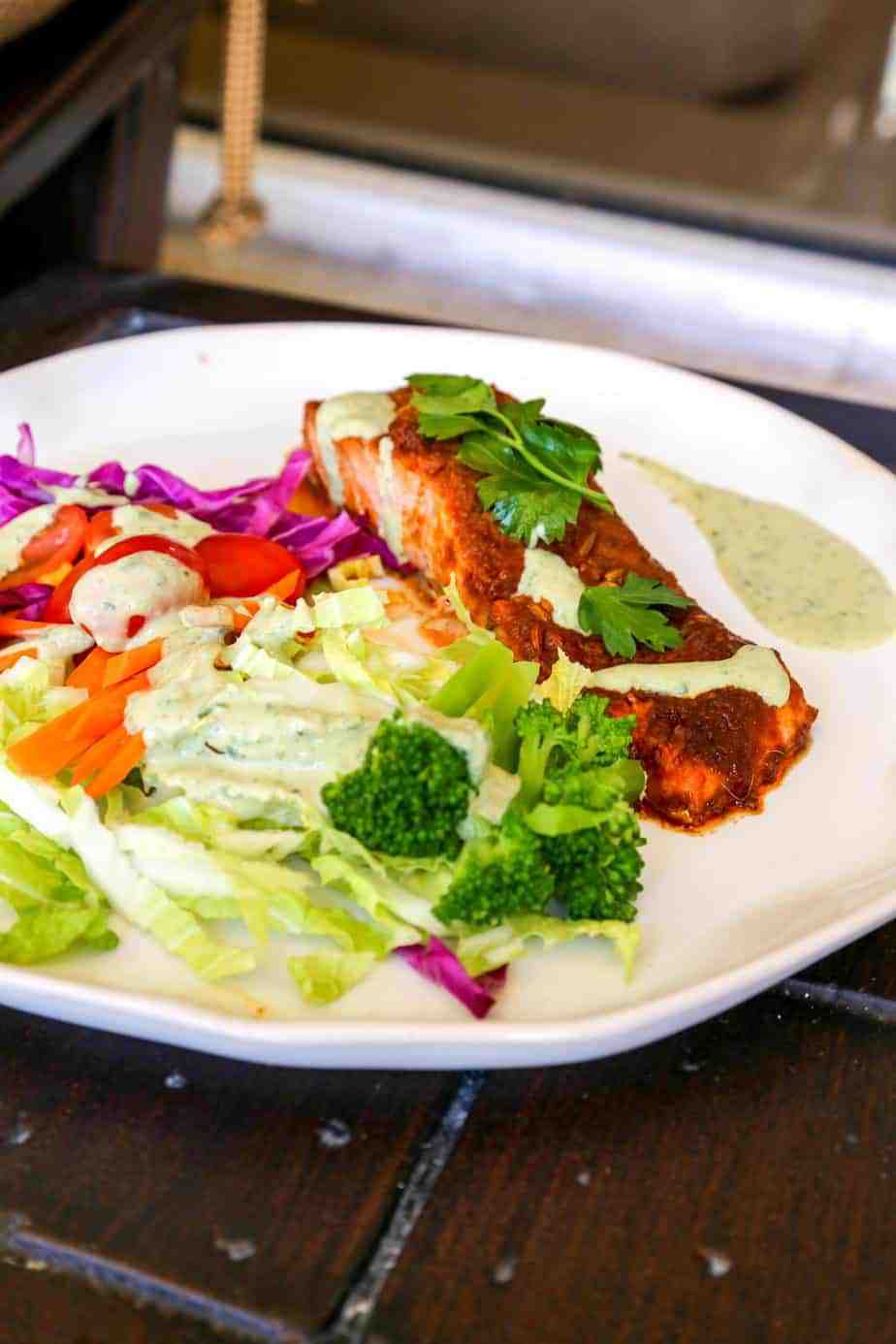 oven baked salmon with Peruvian Spices on a plate with a rainbow salad