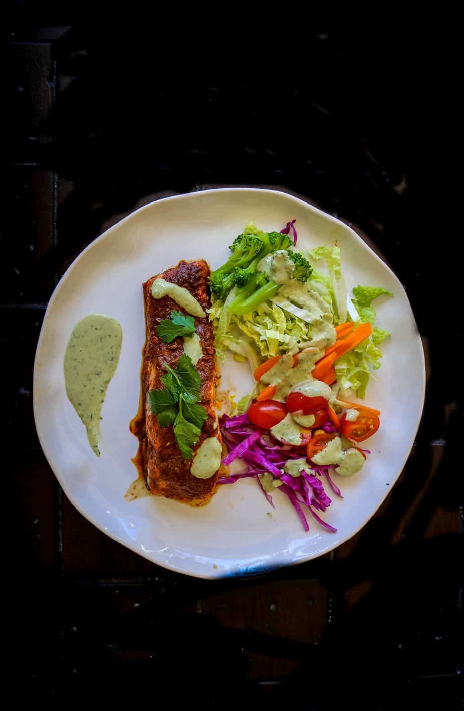 oven baked salmon with Peruvian Spices on a plate with a rainbow salad