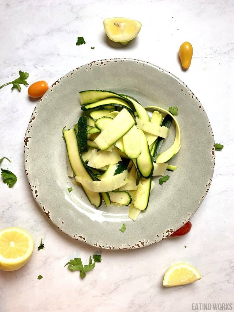 courgette salad with Manchengo Cheese Lemon and Olive Oil on a gray plate