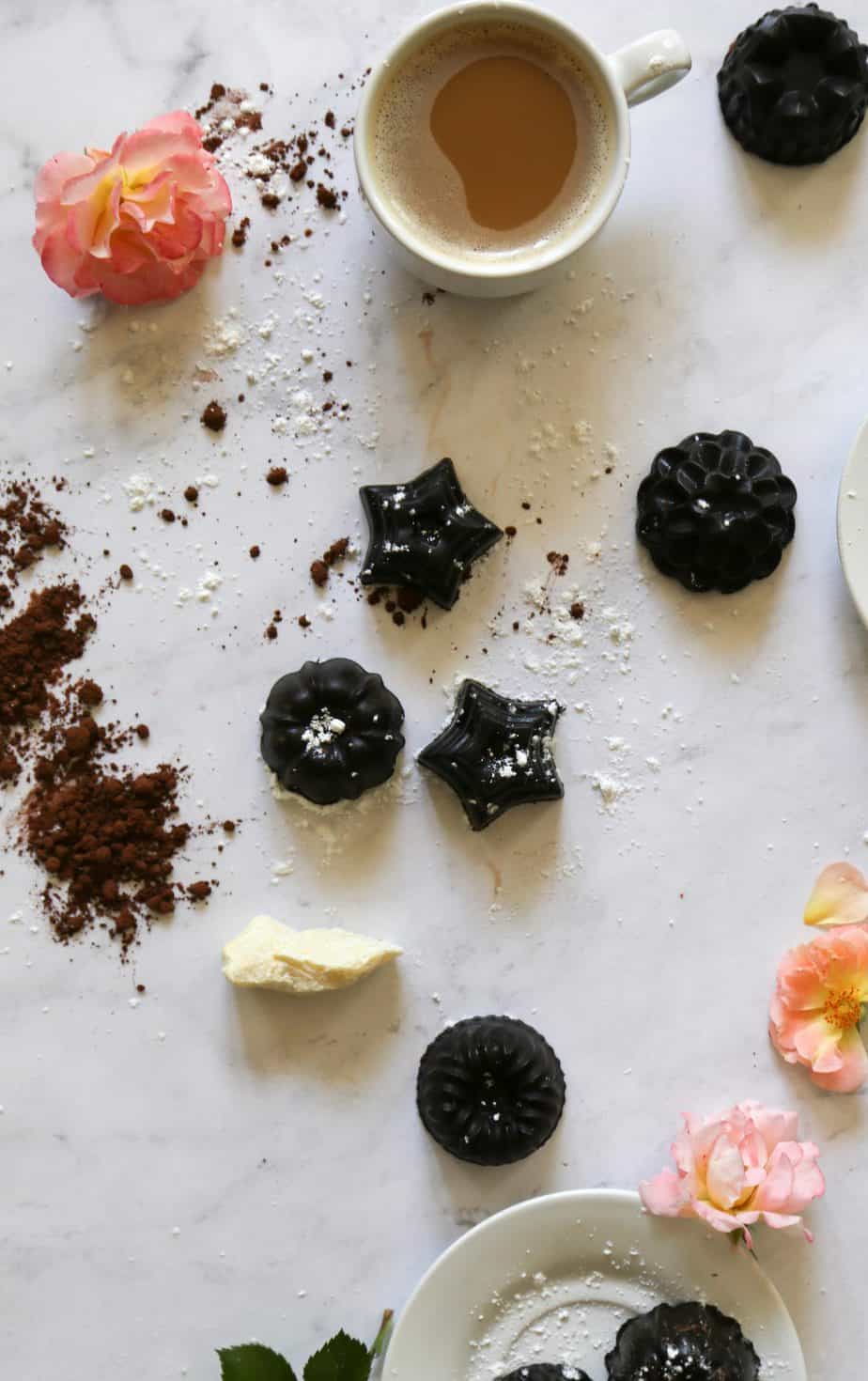 chocolate bon bons on table with coca powder roses cocoa butter and powdered sugar 