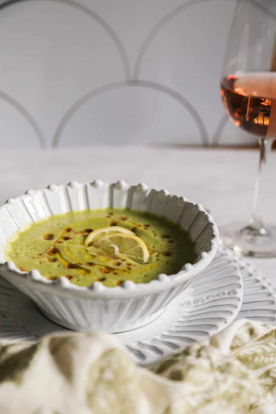 vegan cucumber soup in a white bowl with lemons