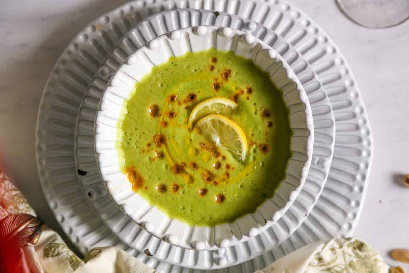 vegan cucumber soup in a white bowl with lemons