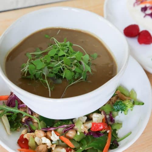 vegan mushroom soup horizontal in a white bowl with Sala with carrots and chickpeas