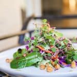 micro green salad with chickpea croutons and green goddess dressing on a plate