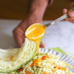 cabbage and carrot salad with carrot ginger miso dressing on a plate
