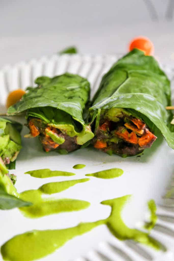 collard green wrap with vegan refried black beans spicy green tahini sauce and cartelized onions and roasted sweet potatoes