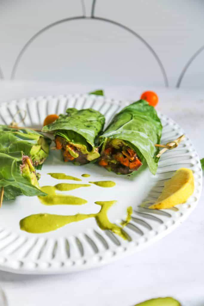 collard green wrap sliced in two pieces on a white plate 