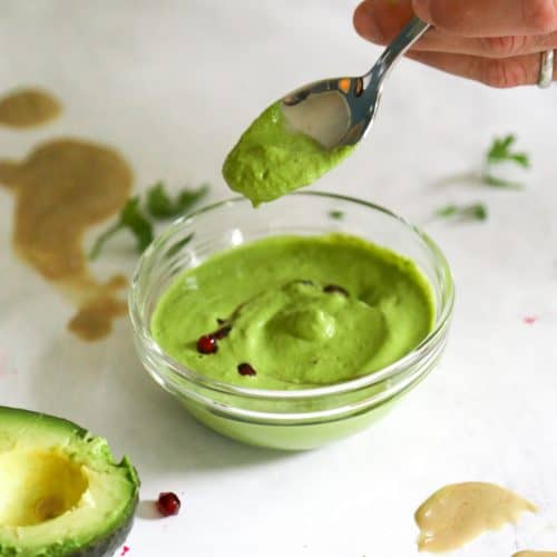 green tahini sauce on a spoon