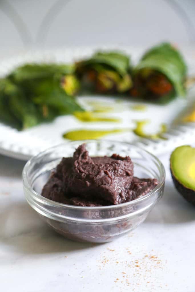 vegan refried black beans made with onions, cumin, canned black beans and lemon juice in a bowl from the side