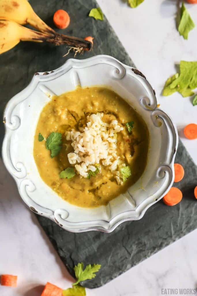vegan split pea soup recipe in a bowl shot from above surrounded by bananas, carrots and celery