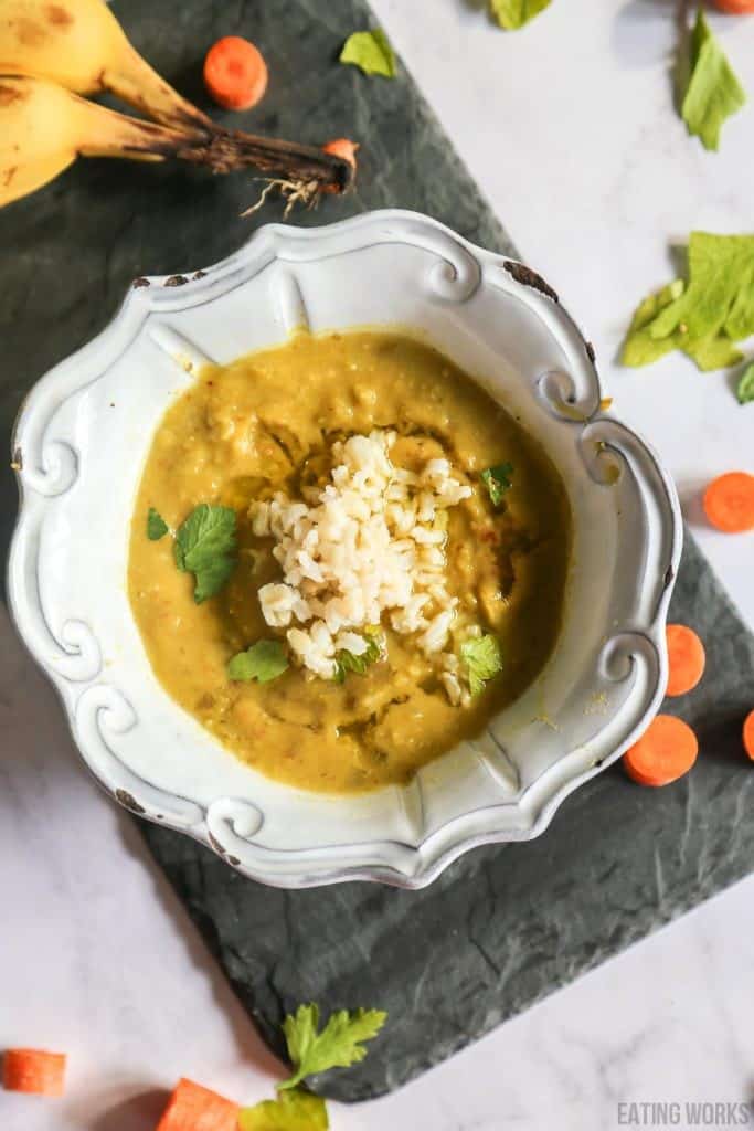 vegan split pea soup in a bowl shot from above surrounded by bananas, carrots and celery