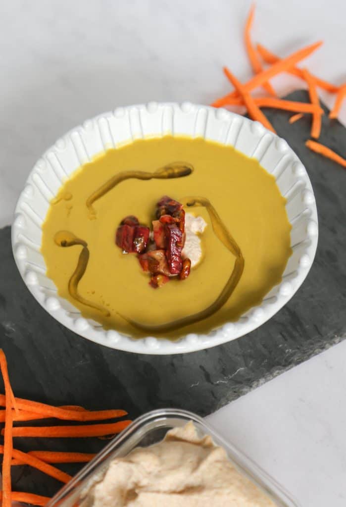 keto broccoli and cheddar soup in a bowl with carrots.