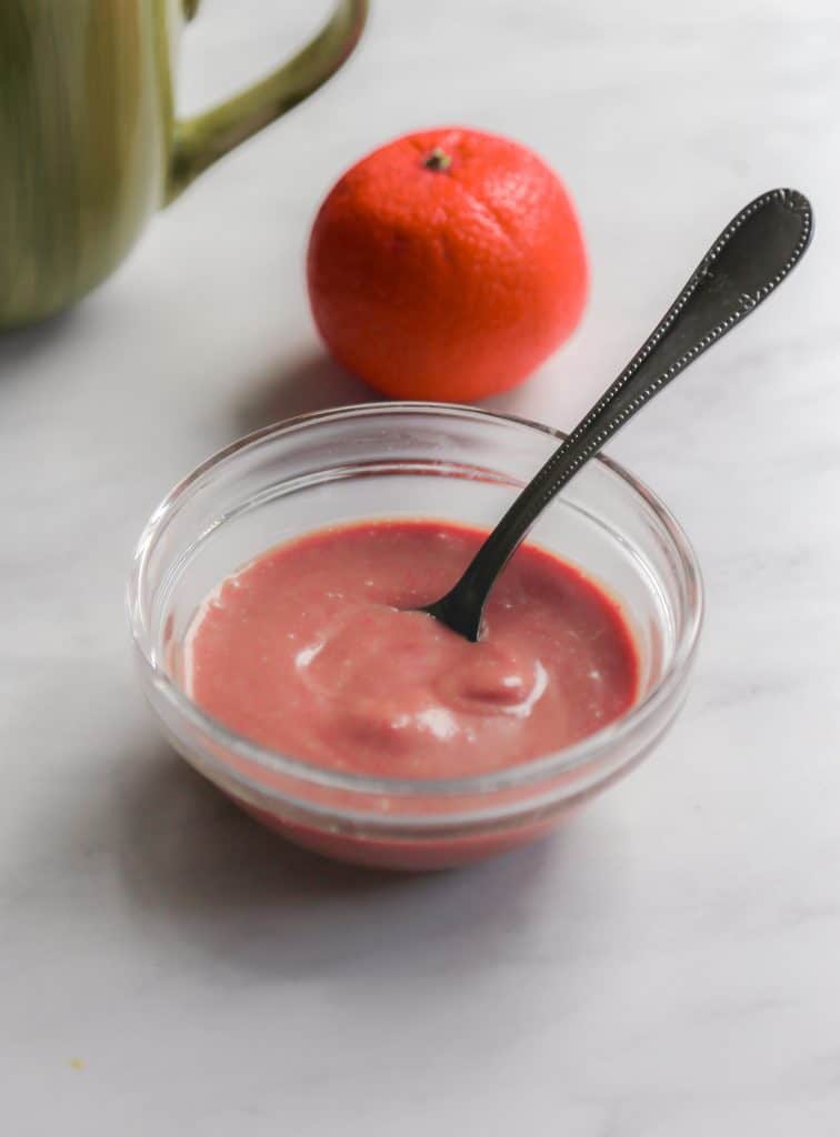 pomegranate vinaigrette in a bowl with a spoon made from pomegranate seeds mustard balsamic and olive oil