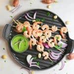 oven baked shrimp kabobs with spicy green tahini sauce on a grill pan from above