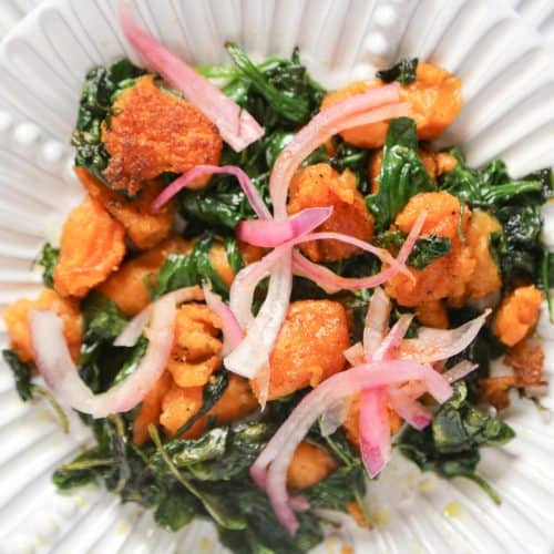 vegan sweet potato gnocchi with sautéed spinach on a white plate made with sweet potatoes and cassava flour