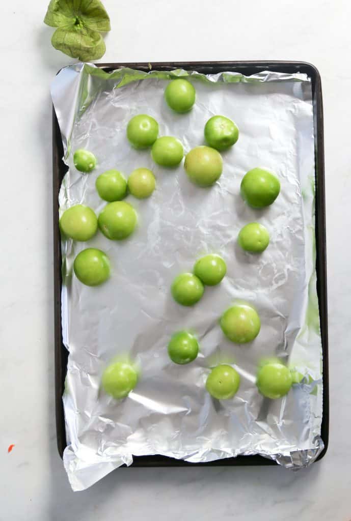 Process shot for spicy tomatillo salsa place tomatillos on a foil lined sheet tray