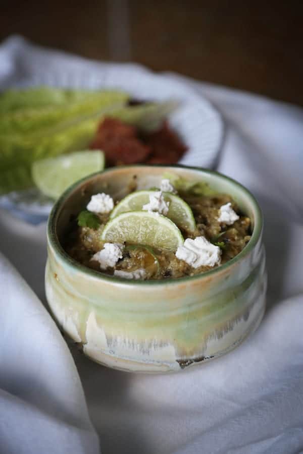 spicy tomatillo salsa in a bowl with limes on top