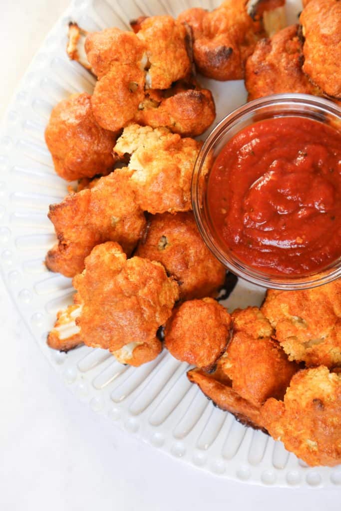  keto cauliflower wings on a white plate with bbq sauce