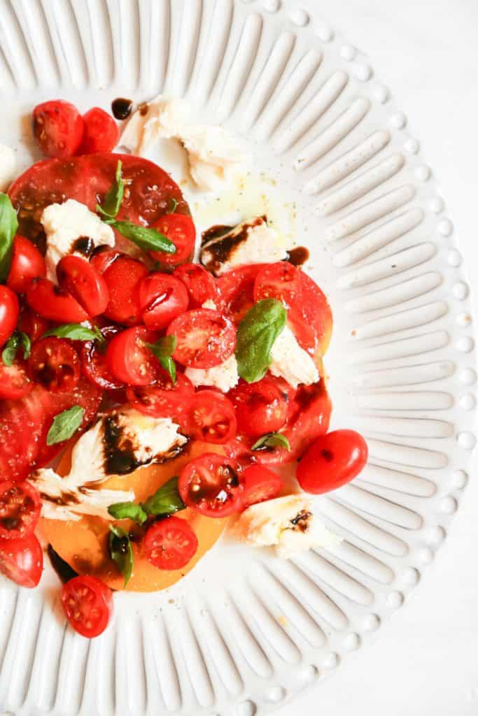 Keto Caprese salad with keto balsamic vinegar on a white plate 