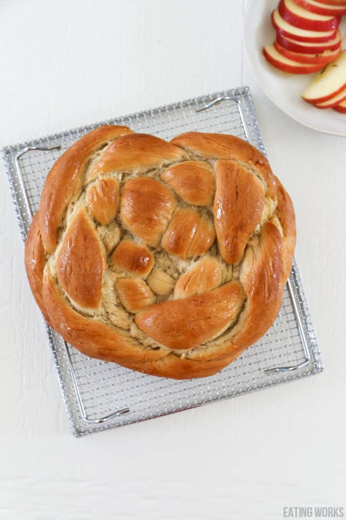 vegan round challah on a baking rack on a white table