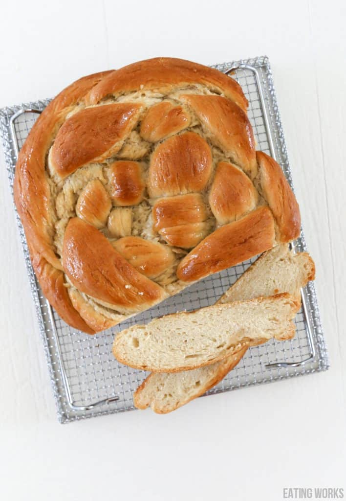 vegan challah on a cooling rack with two cut slices 