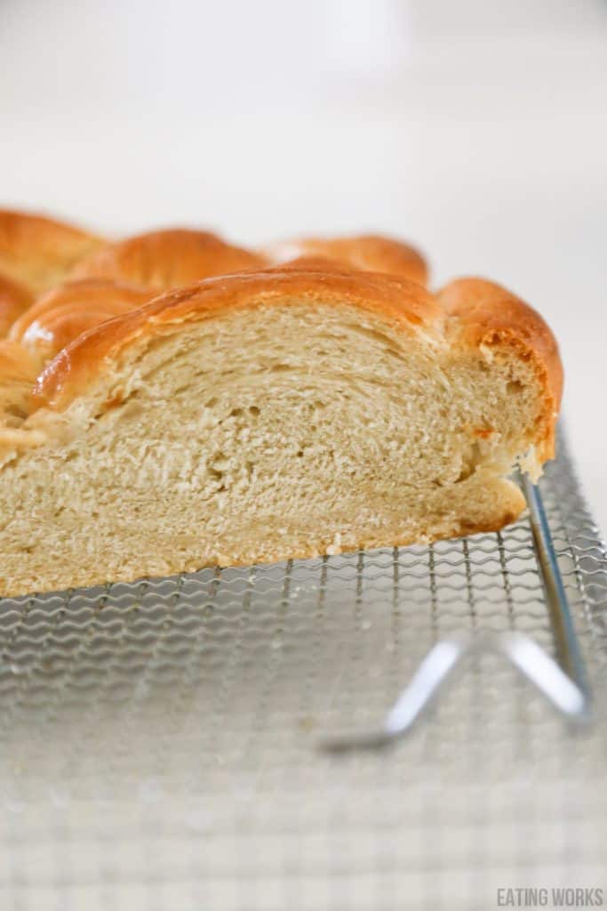 vegan challah sliced inside is visible on a cooling rack