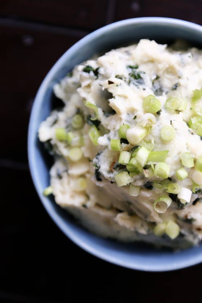 parsnip mash in a bowl garnished with scallions