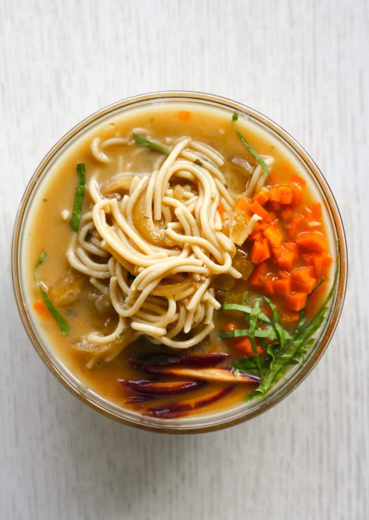 gluten free ramen noodle soup in a bowl with gluten free ramen noodles, carrots, lettuce and onions