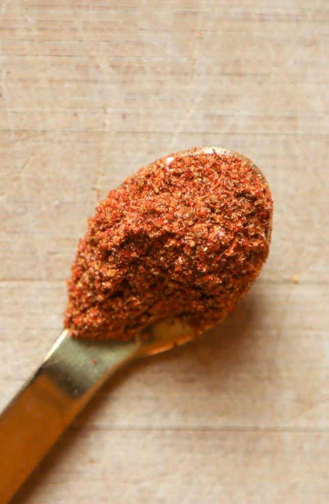 photo of Peruvian spice blends a gold spoon with paprika, cumin, sea salt, fennel and mustard seed.