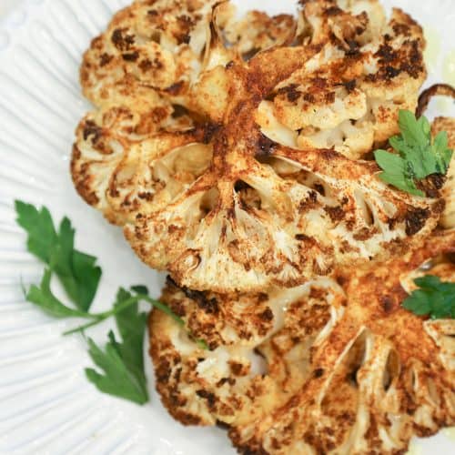 air fryer cauliflower steaks on a white plate