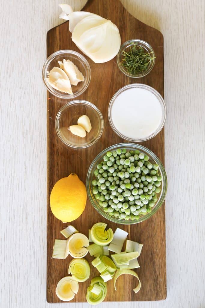 photo of ingredients for vegan pea soup including lemon, leaks peas, lemon, coconut milk, vegan butter and thyme