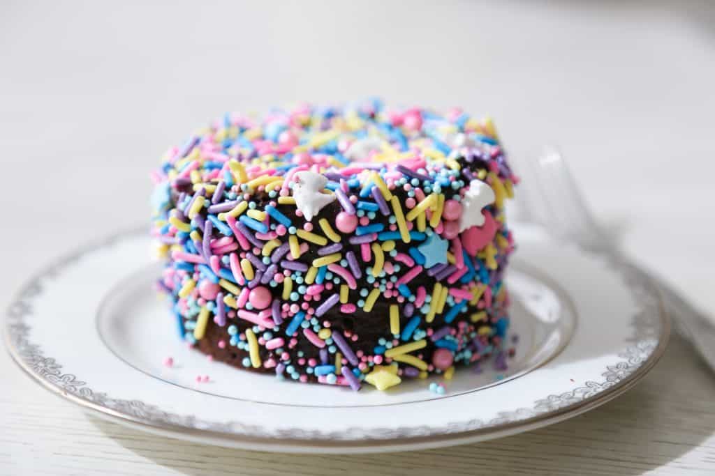 gluten free bento cake covered in sprinkles on a cake plate 