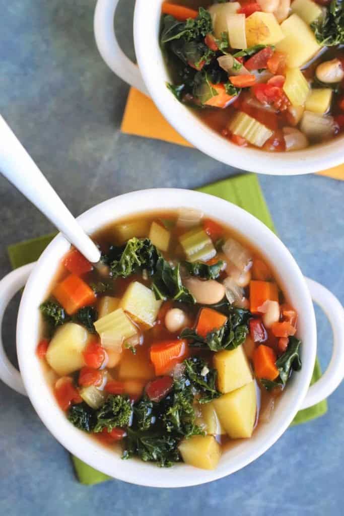 vegan chunky vegetable soup in a crock with a spoon