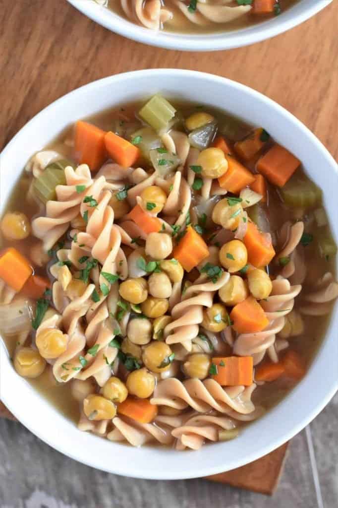 gluten free chickpea and noodle soup in a white bowl