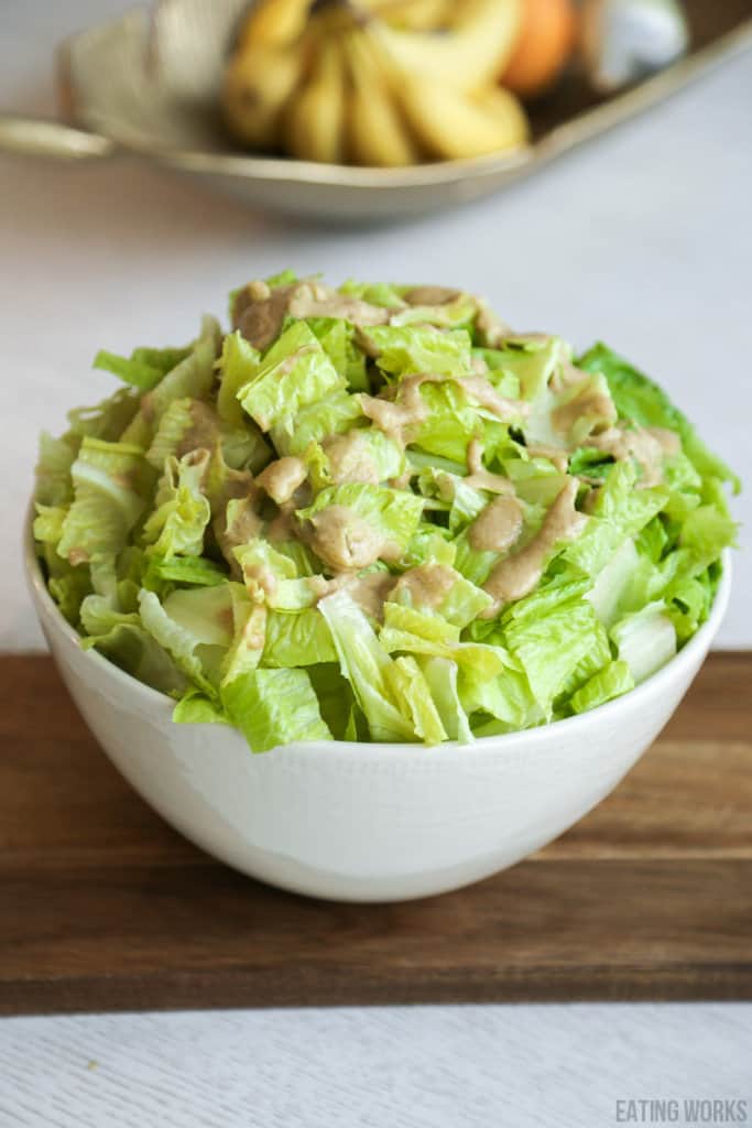 healthy caesar salad dressing recipe in a white bowl with romaine lettuce