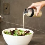 vegan Italian dressing recipe pouring into a salad in a bowl