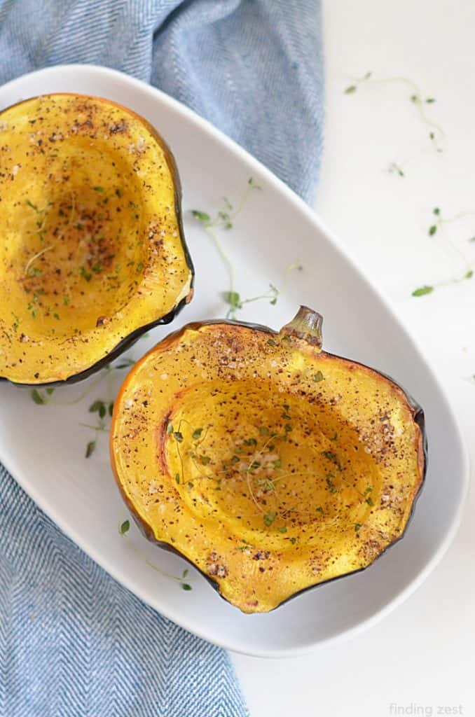 air fryer acorn squash on a plate sliced in a half