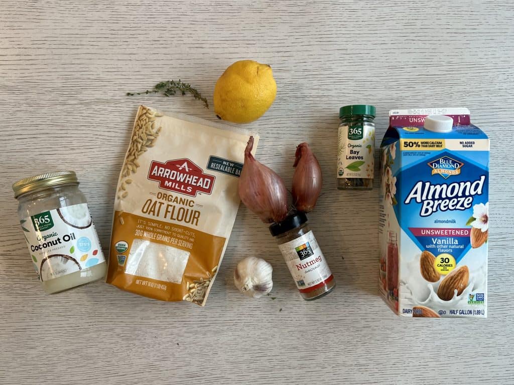ingredients for vegan and gluten free white sauce coconut oil, oat flour, shallots, garlic, nutmeg, bay leaves, thyme, lemon, almond milk