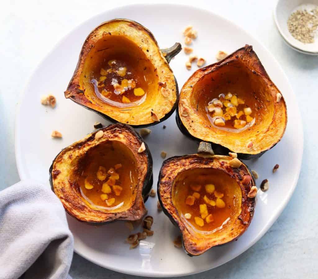 air fryer acorn squash on a plate with hazelnuts 