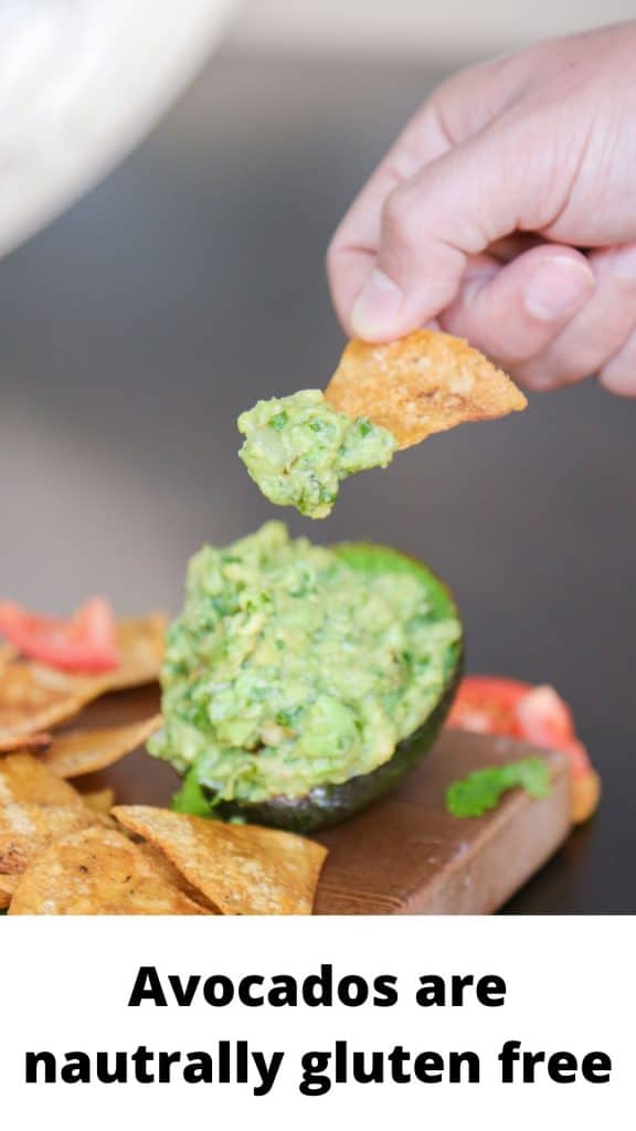 photo of hand dipping tortilla chip into guacamole with text that says avocados are gluten free.