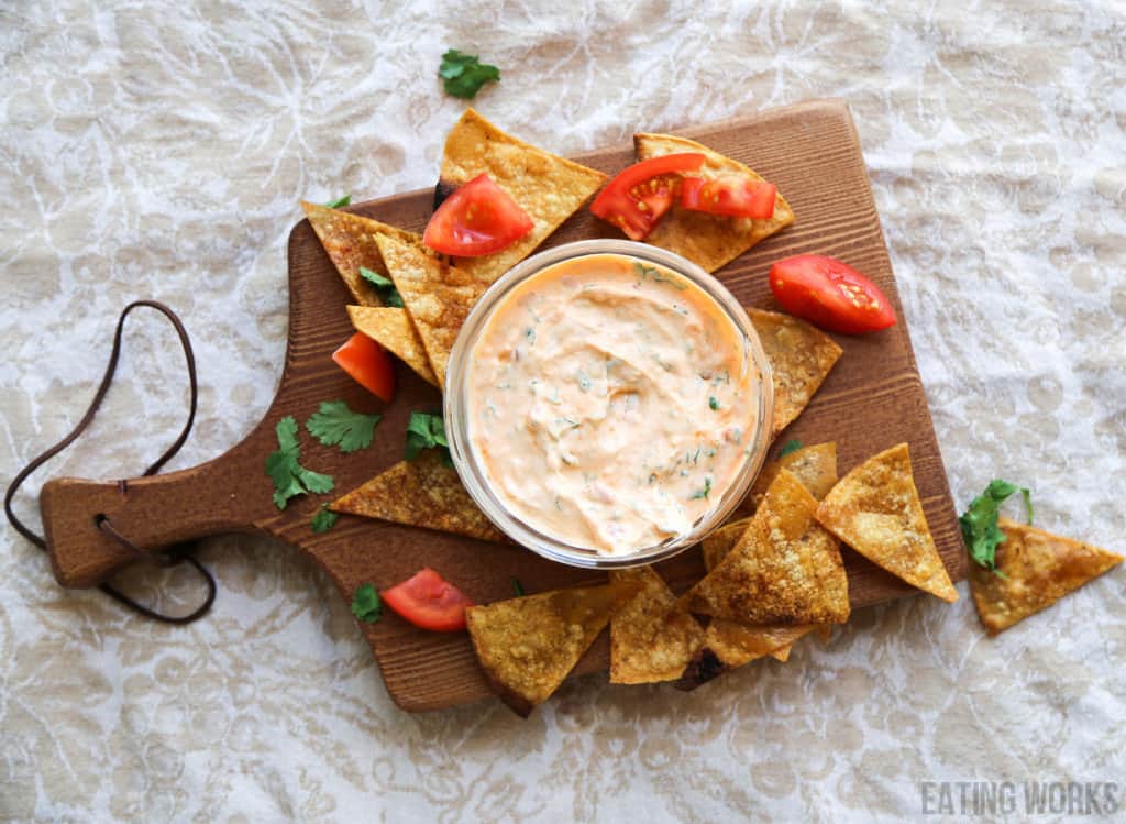 Harissa yogurt sauce with tortilla chips on a cutting board