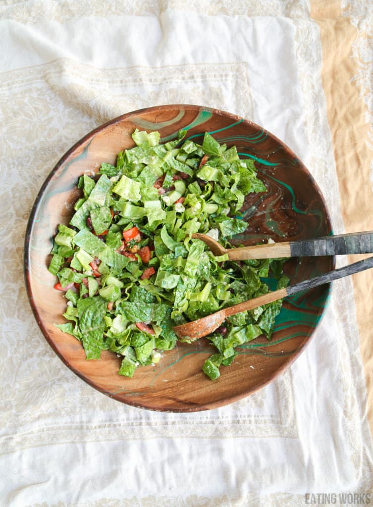 keto friendly greek salad in a wooden bowl with serving spoon and fork