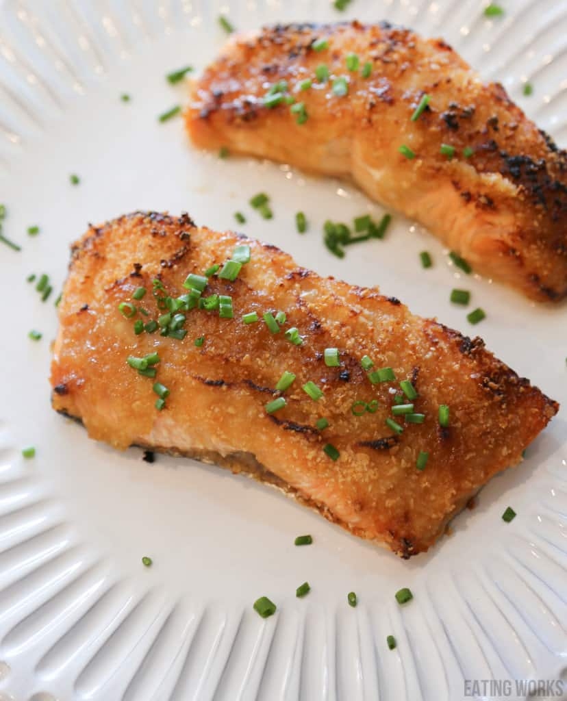 air fryer salmon with dijon mustard sauce garnished with chives on a white plate