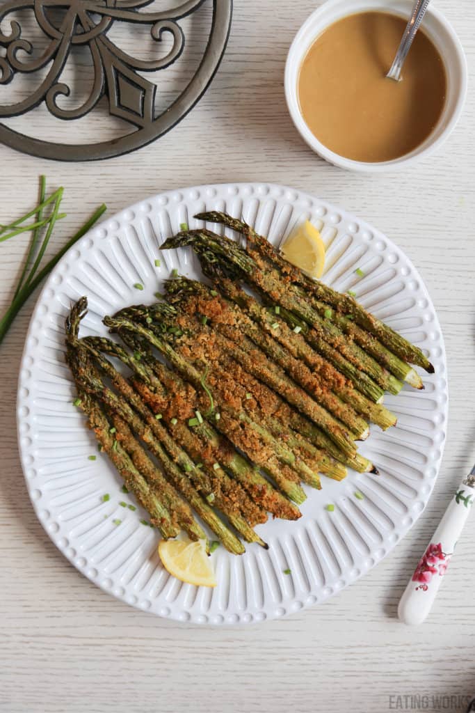 air fryer asparagus on a plate with lemon wedges