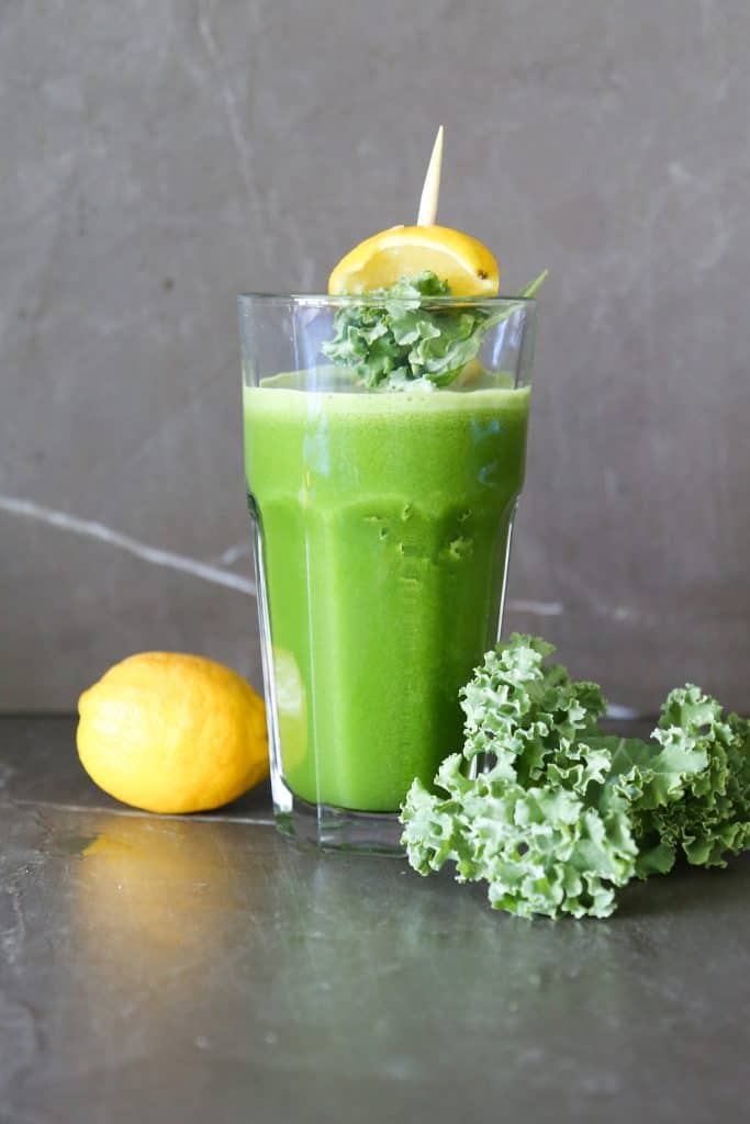 first watch kale tonic in a glass with kale and lemons