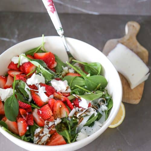 strawberry and goat cheese salad in a white bowl